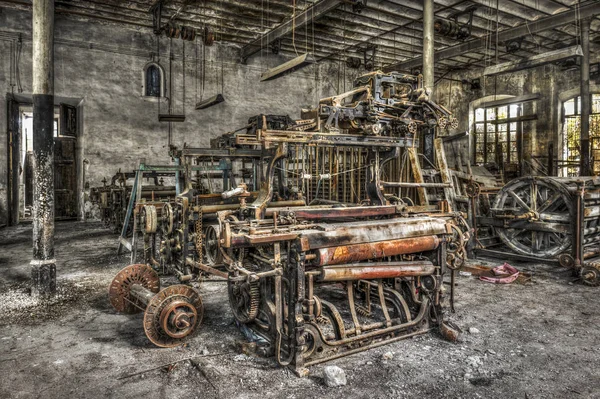 Oude weven van weefgetouwen en machines op een verlaten fabriek spinnen Stockfoto
