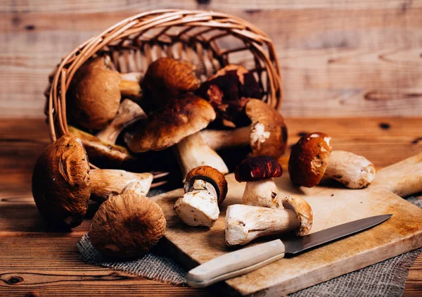 Boletus mushrooms in a basket on a wooden board — Stock Photo, Image