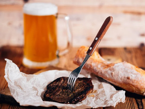 Carne en la parrilla y una taza de cerveza . —  Fotos de Stock