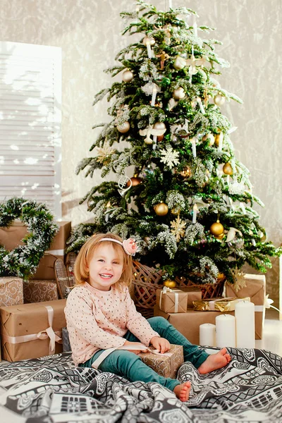 Child with gift on background of the Christmas tree — Stock Photo, Image