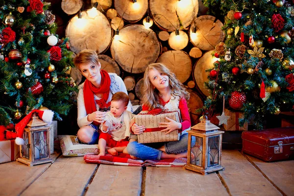 Kid with mother receiving gifts under Christmas tree — Stock Photo, Image