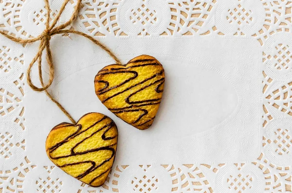 Heart shaped holiday gingerbread cookies lie on a white napkin.