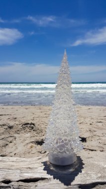 Plajda şeffaf Noel ağacı süsle