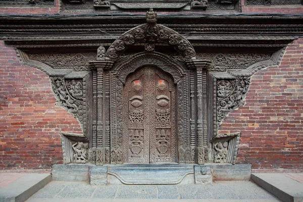 An elegantly engraved wooden door at Patan Durbar Square in Lalitpur, Kathmandu, Nepal.