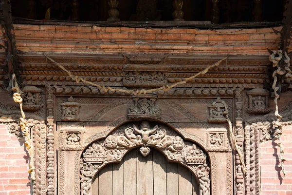 An elegantly engraved wooden door at Patan Durbar Square in Lalitpur, Kathmandu, Nepal.