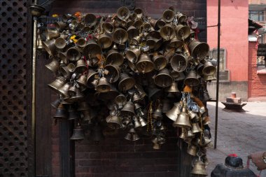 Katmandu, Nepal - 29 Nisan 2017: Lalitpur 'daki Bangalamukhi tapınağının duvarına bağlılar tarafından bağlanmış bir grup çan.