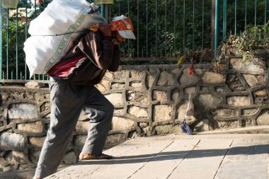 Kathmandu, Nepal - 11 Kasım 2017: Swoyambunath 'da bilinmeyen bir adam bazı malzemeler taşıyor..