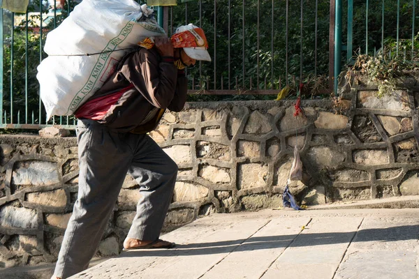 Kathmandu, Nepal - 11 Kasım 2017: Swoyambunath 'da bilinmeyen bir adam bazı malzemeler taşıyor..