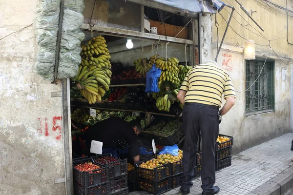 Beyrut, Lübnan - 9 Haziran 2017: Sıradan giyinen yaşlı adam sokak köşesindeki bir dükkandan meyve alıyor.