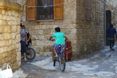 Batroun, Lübnan - 15 Ekim 2017: Eski kasaba bölgesinde çocuklar bisiklete biniyor.
