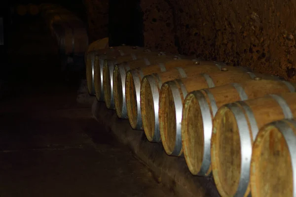 Old wine barrels arranged in a cave.