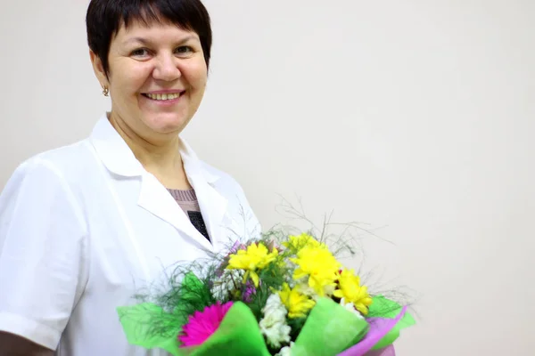 A doctor with a bouquet of flowers