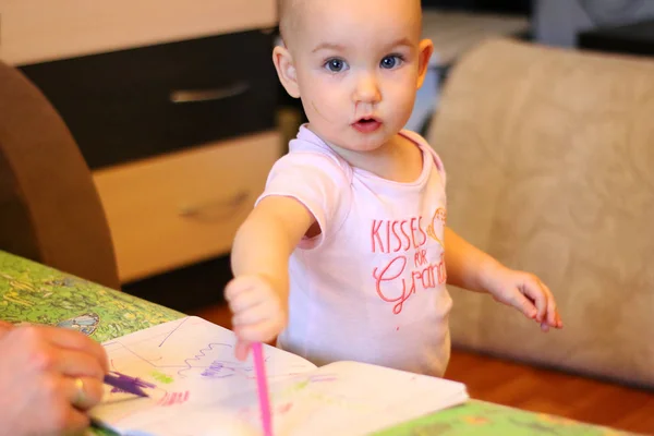 A little girl drawing her first pictures