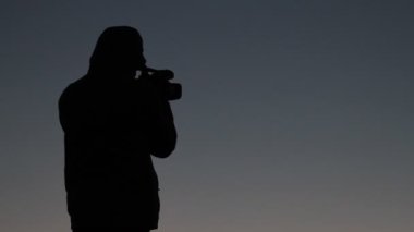 Kontrast adam video kamera ile dağda gün batımı ayakta