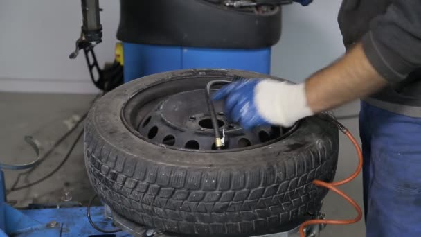 Mechanik samochodowy, przykręcenie koła do samochodu — Wideo stockowe