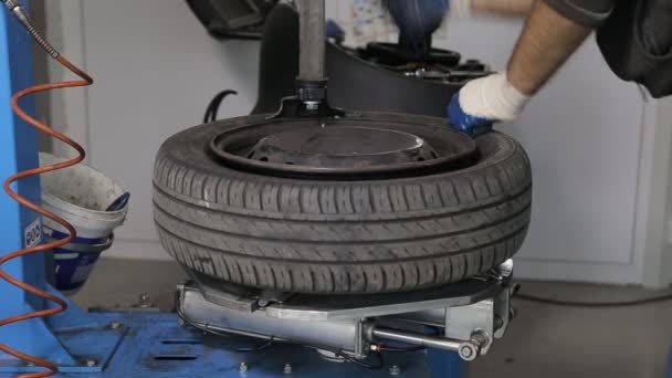 Автомеханик прикручивает колесо к машине — стоковое видео