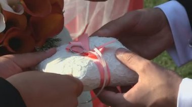 Gelin damadın parmağına alyans takıyor.