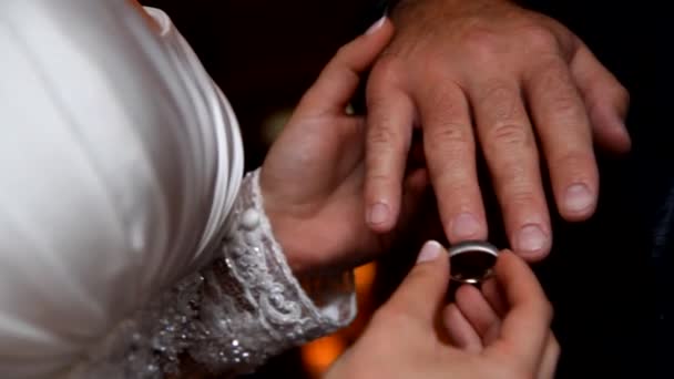 Novia poniendo un anillo de bodas en el dedo del novio — Vídeo de stock
