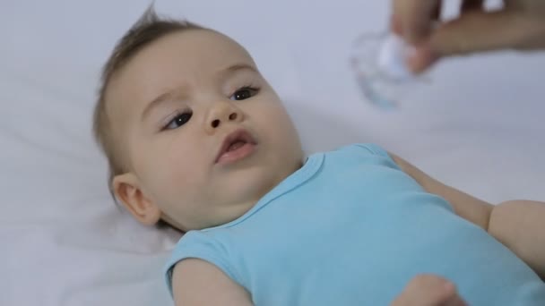 Bebé con chupete en la cama — Vídeo de stock