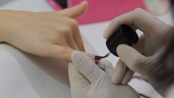 Процесс маникюра в салоне красоты, показывающий окраску и рисунок на искусственном ногте — стоковое видео