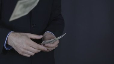 İşadamı para kameraya atar.