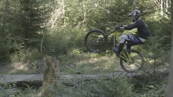 Man on mountain bike riding bike in the forest and performing tricks and jumps — Stock Video