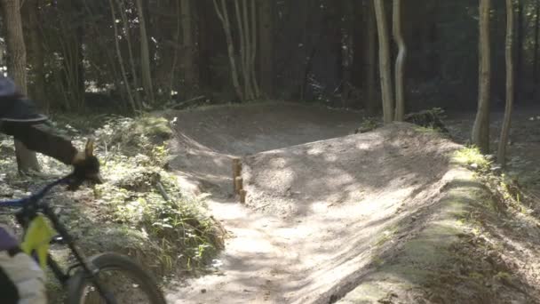 Hombre en bicicleta de montaña montar en bicicleta en el bosque y realizar trucos y saltos — Vídeo de stock