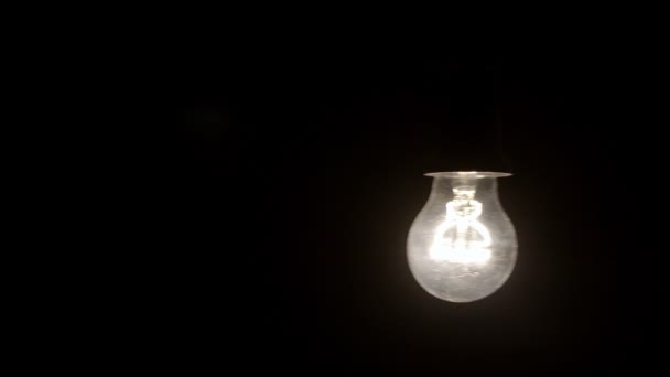 Glowing hanging light bulb dangle on a wire loop 4K — Stock Video