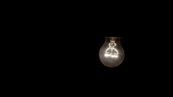 Glühende hängende Glühbirne baumelt an einer Drahtschlinge 4k — Stockvideo