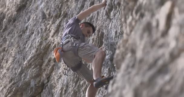 Un escalador masculino trepa por una roca — Vídeos de Stock