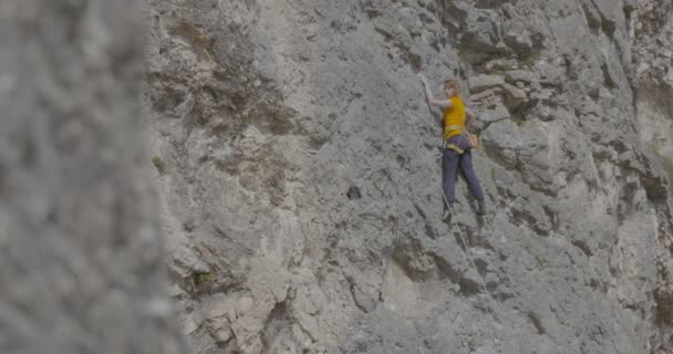 Bir kadın dağcı bir kayayı tırmanıyor — Stok video