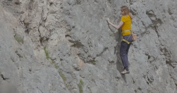 Ένα θηλυκό βράχο ορειβάτης ανεβαίνει ένα βράχο — Αρχείο Βίντεο