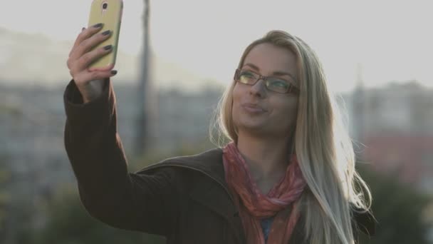 Frau schreibt SMS auf Smartphone im Park in der Stadt — Stockvideo