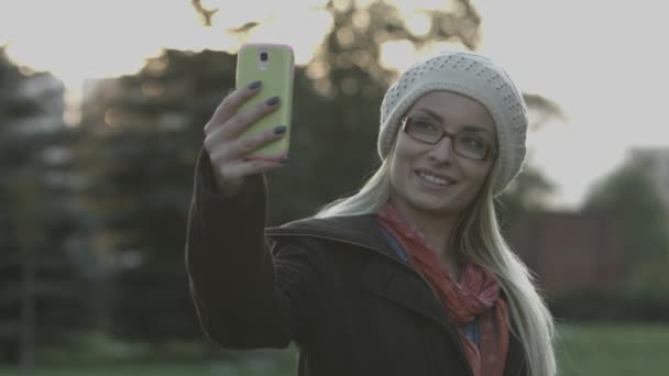 Ελκυστική νεαρή γυναίκα, λαμβάνοντας μια selfie τον εαυτό της με το έξυπνο τηλέφωνο — Αρχείο Βίντεο