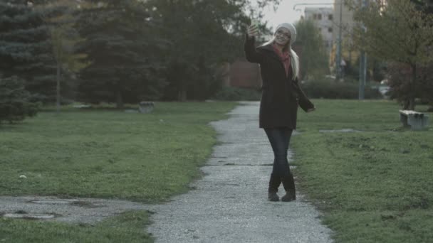 Žena sms textových zpráv na mobilní telefon v parku ve městě — Stock video