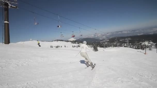 Vrouwelijke skiër naar beneden op de ski route — Stockvideo