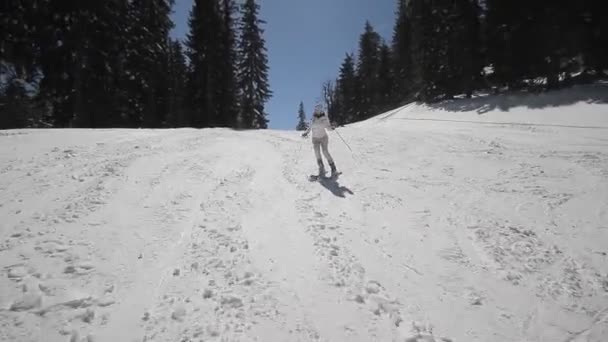 Жіночий гірськолижник спускається по лижному маршруту — стокове відео