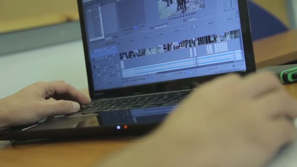 Человек работает на ноутбуке с программным обеспечением для редактирования видео — стоковое видео
