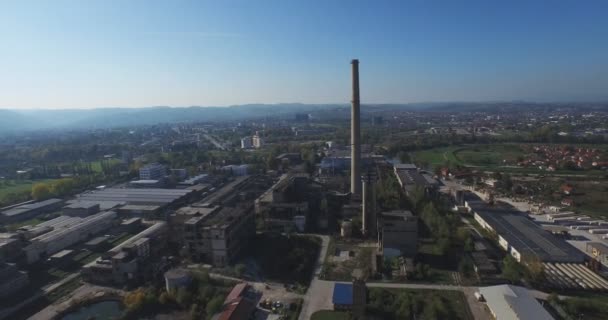 Vista aérea de edificios industriales abandonados y chimenea al atardecer — Vídeos de Stock