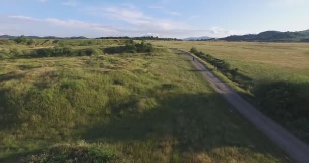 Aerial de motard monte une moto sur le vieux chemin de terre 