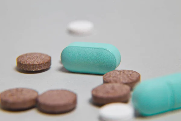 Un paquet de pilules bleues avec une injection verte en arrière-plan. Outils médicaux . — Photo