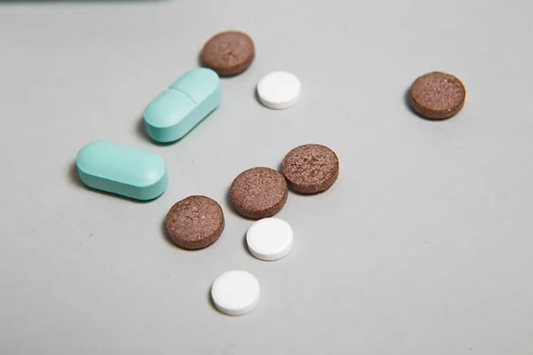 Куча синих таблеток с зеленой инъекцией на заднем плане. Медицинские инструменты . — стоковое фото