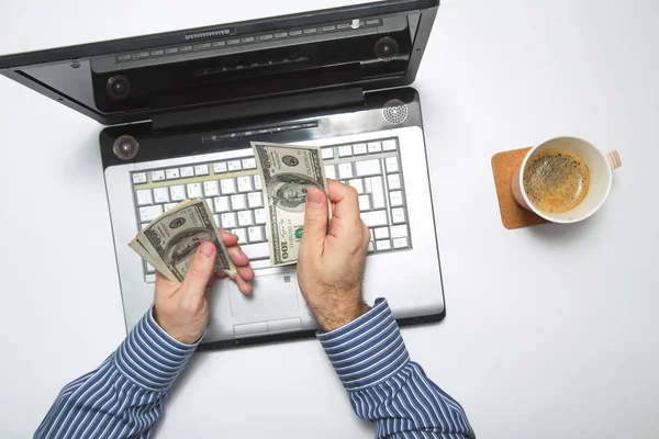Dizüstü bilgisayarda çalışan ve kahve içiyor gibi süre para sayma işadamı — Stok fotoğraf