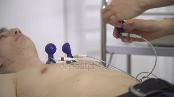 Femme médecin surveille les progrès de la un jeune homme ECG — Video