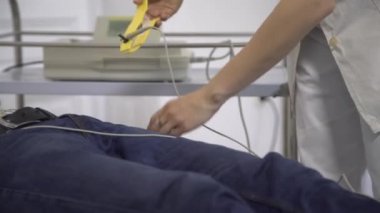 Kadın doktor ilerlemesini izler bir genç adam EKG