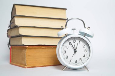 Beyaz arka plan üzerinde izole kitap masada Vintage beyaz çalar saat