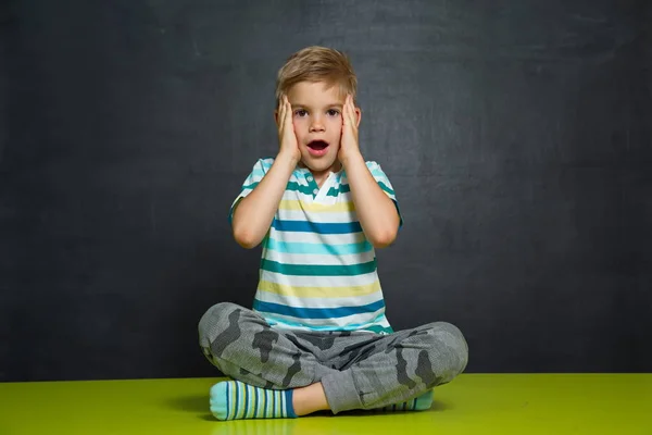 School boy is standing with blackboard behind him — Stock Photo, Image