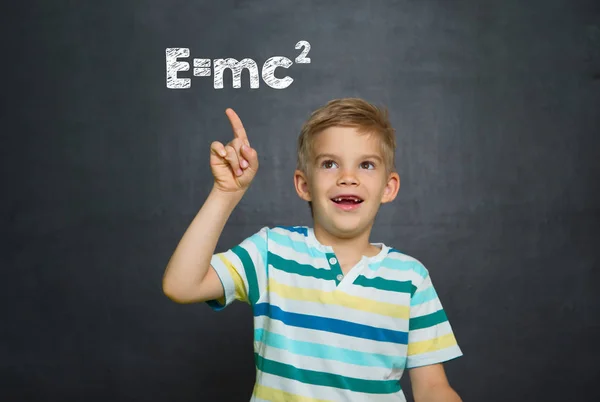 Boy in front of school board with text Emc2 — Stock Photo, Image