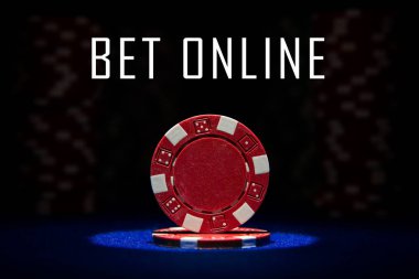 Yonga üzerinde spot ışığı ile mavi keçe kart masa yüzeyi kırmızı poker chip closeup