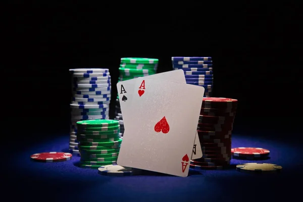 Par de ases e fichas de poker em fundo preto — Fotografia de Stock